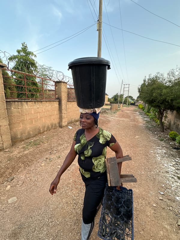 Woman carries container on head in Bukuru, Nigeria