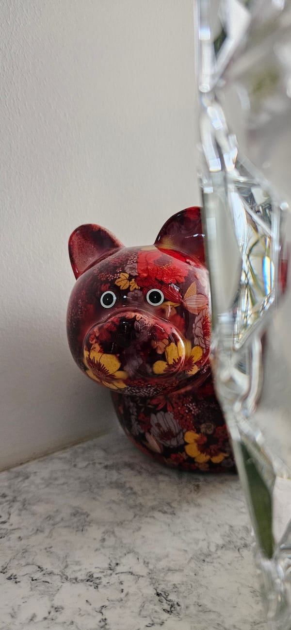 Ceramic pig and bronze Buddha on a marbled countertop