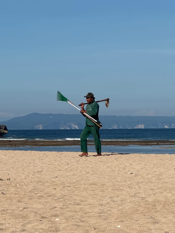 Beach cleanup worker and children spotted on Kuta Selatan shore
