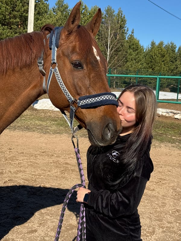 Woman shares quiet moment with horse in rural Russia