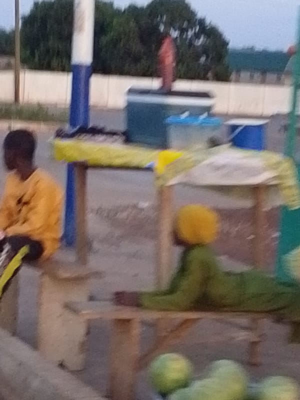 Two people rest outdoors in Baglahi, Ghana