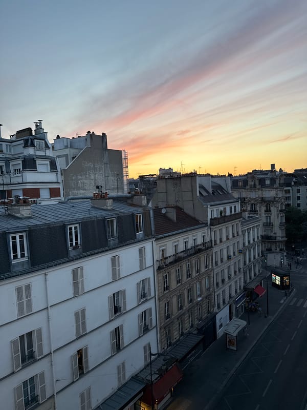 Rooftop-level Paris at golden hour, cafes and classic architecture