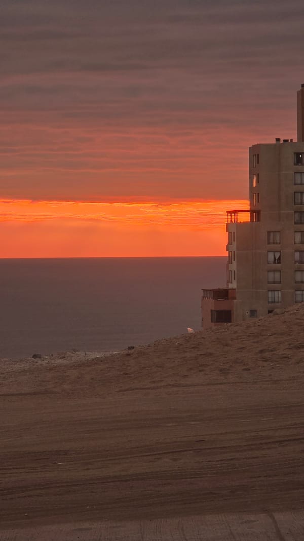 Sunset paints orange and pink sky over Iquique, Chile