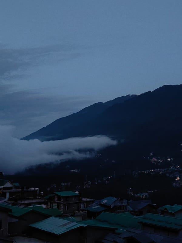 Vashisht village at dusk, Himalayan peaks in the background