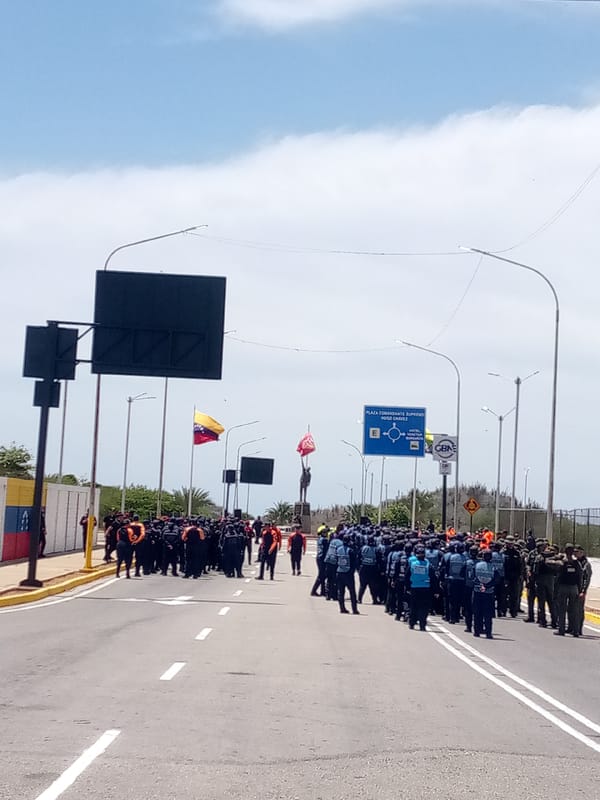Uniformed personnel gather on busy Porlamar street during afternoon