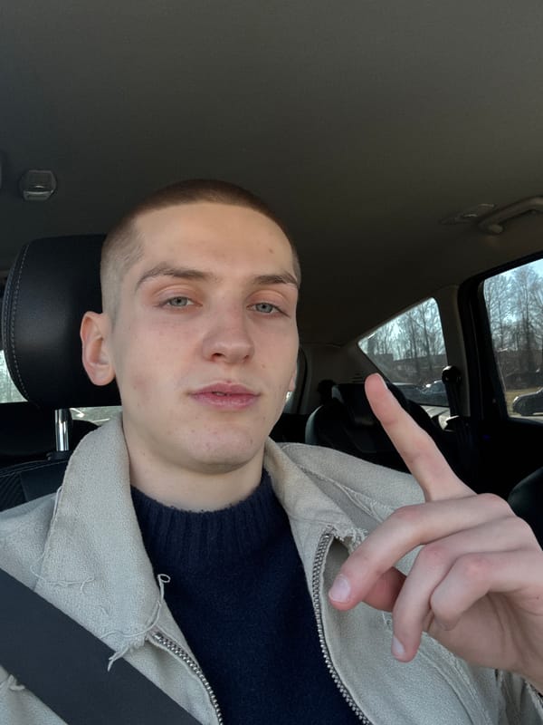 Young man makes peace sign in car in Riga