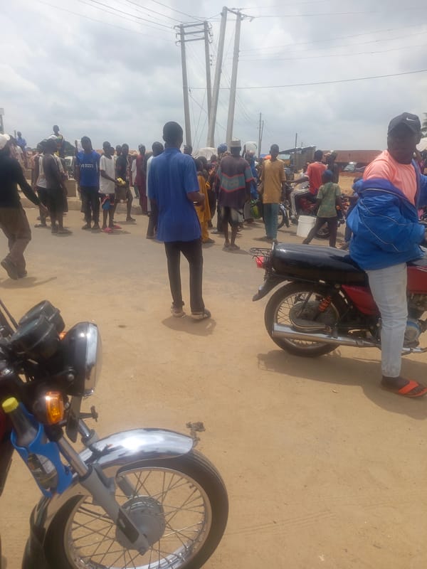 Community gathers around motorcycle on Akwanga street