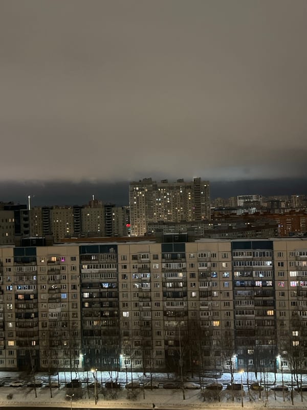 Saint Petersburg apartment towers glow against winter night fog
