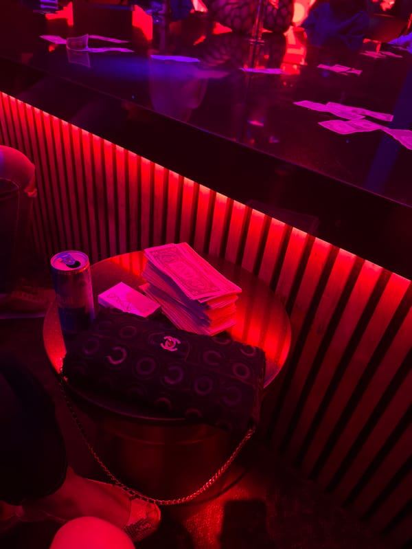 Red-lit table scene with cash, purse observed in West Hollywood
