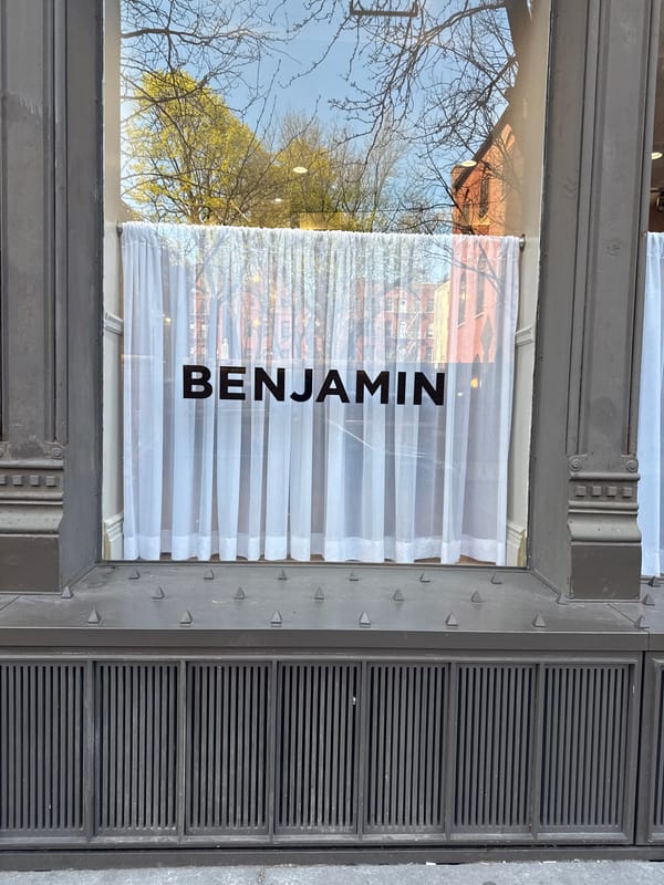 Benjamin storefront window observed in New York evening