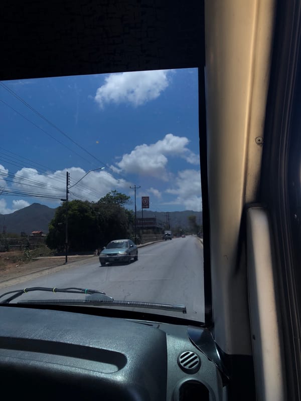 Vehicle journey documented through windshield in Venezuelan countryside