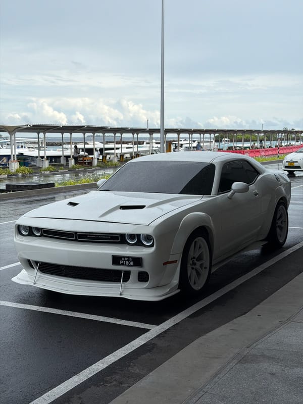White Dodge Challenger spotted on wet pavement in Malé