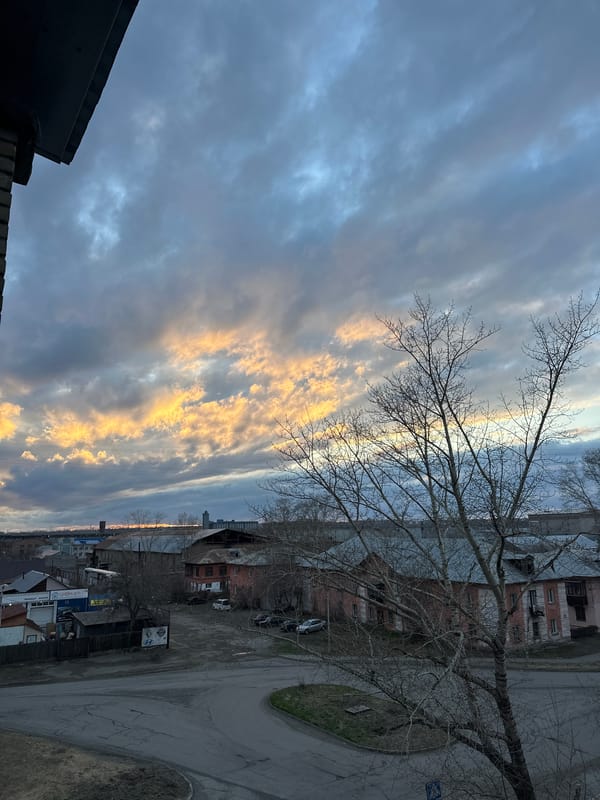Dramatic sunset illuminates urban skyline with golden clouds