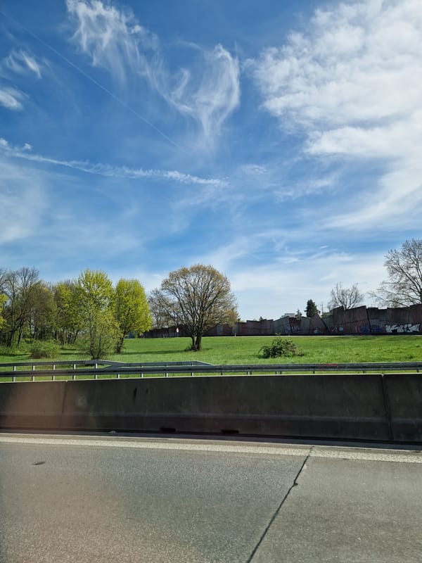 Vehicle travels Karlsruhe highway under blue skies with clouds