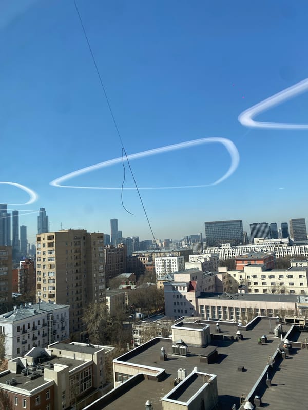 Moscow cityscape captured under clear skies with contrails