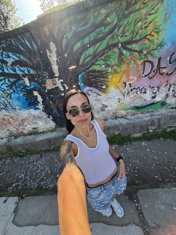 Woman takes outdoor selfies near graffiti wall in Bulgaria