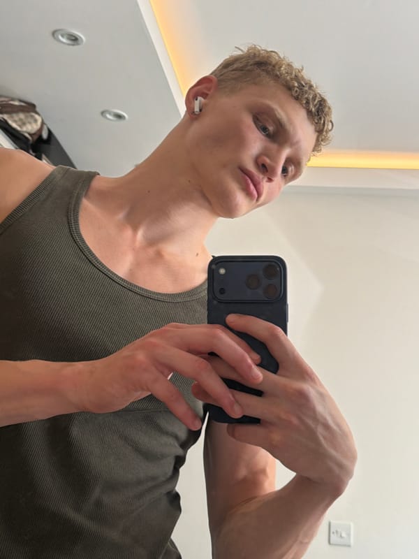 Mirror selfie in a London changing room, green ribbed tank top.