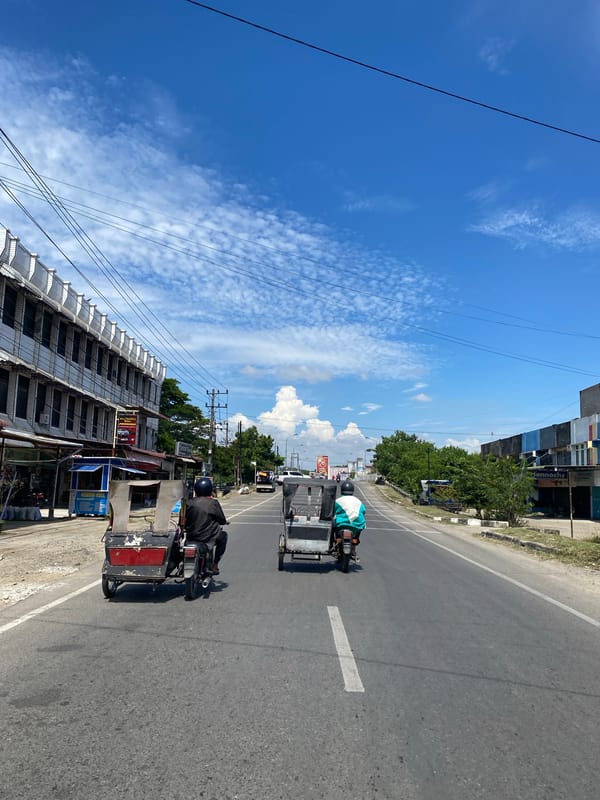 Becaks and scooters on a sunny Lhokseumawe street