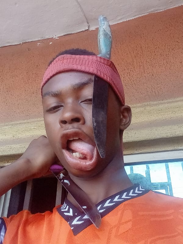 Street performer demonstrates blade balancing act in Nkpor, Nigeria