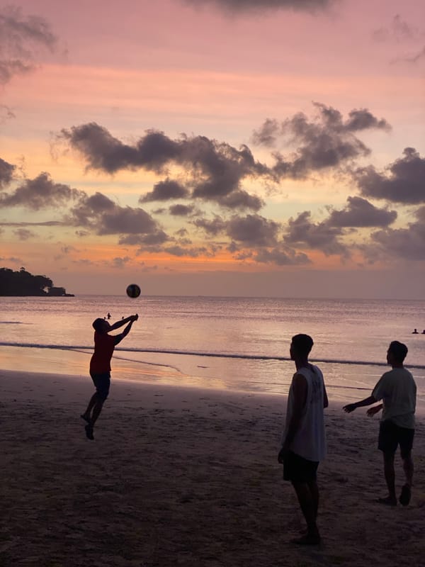 Dusk gathering on a Kuta Selatan beach under a colorful sky