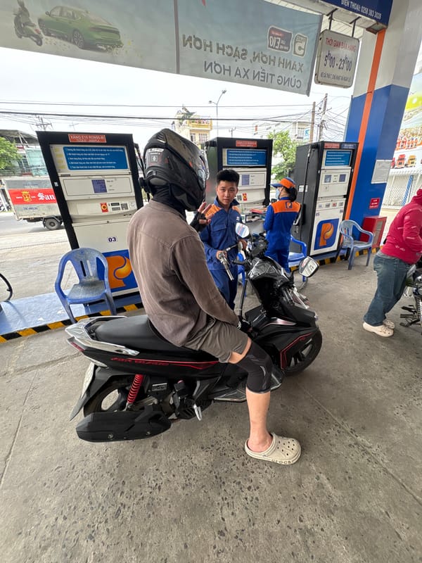 Motorcyclist refuels at Vietnam gas station during morning commute