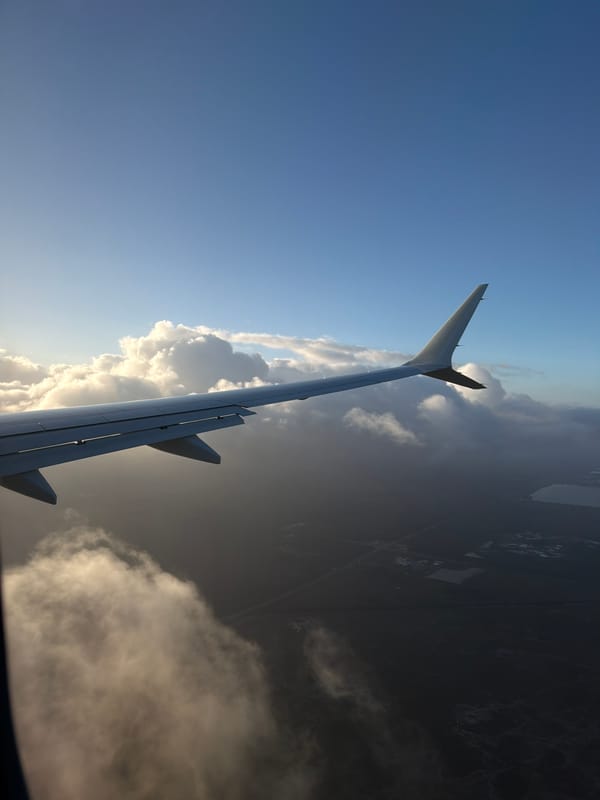 Passenger photographs airplane wing view over Tamiami