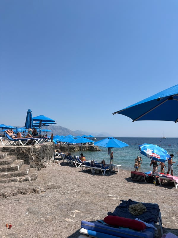 Busy blue-chair beach day on the Montenegrin coast