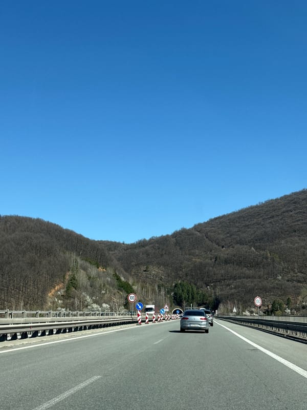 Silver car travels highway in Vrachesh amid construction signs