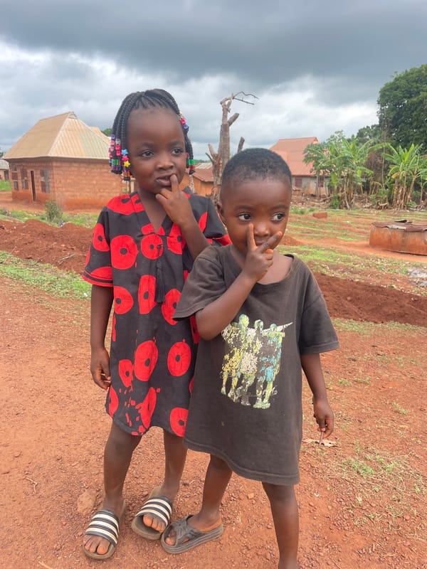 Two children stand together in Ogbe, Nigeria morning scene