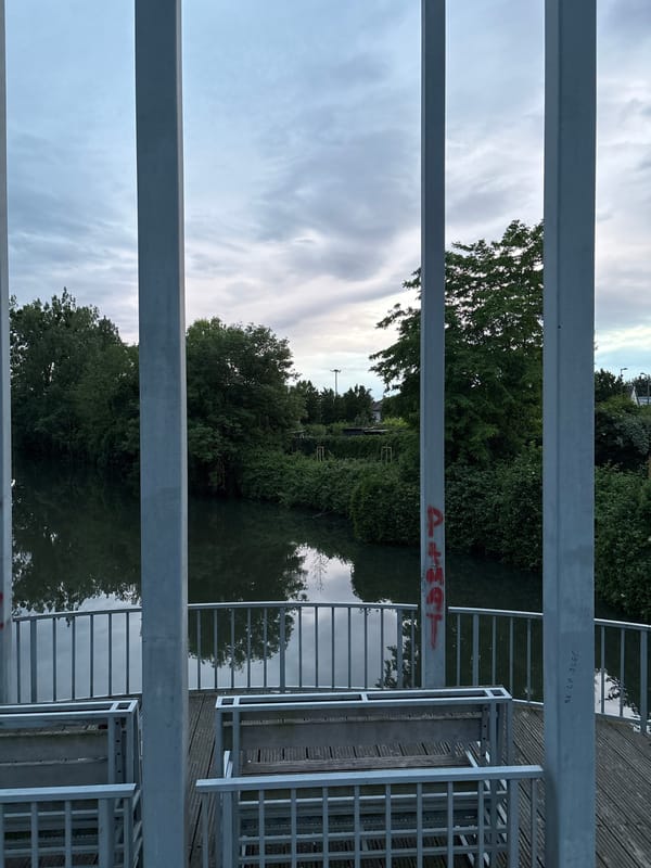 Bridge walker documents waterway reflections during evening stroll