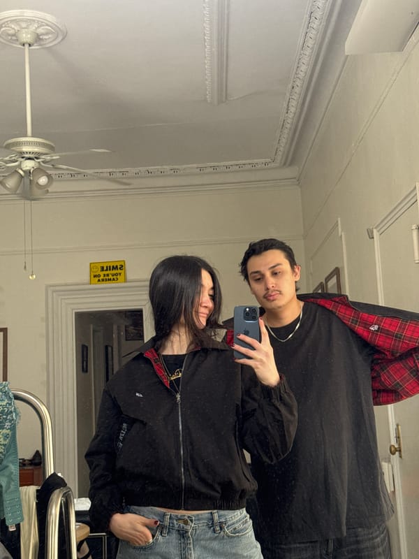 Two people take mirror selfie in New York room