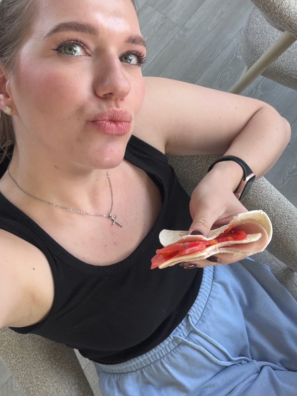 Woman takes selfie with sandwich in Dreiliņi, Latvia