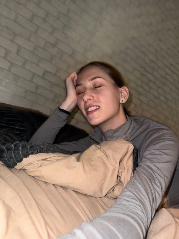 Woman rests on bed in Sofia apartment