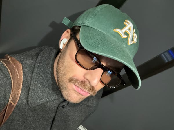 Man takes elevator selfie in Montreal wearing Athletics cap