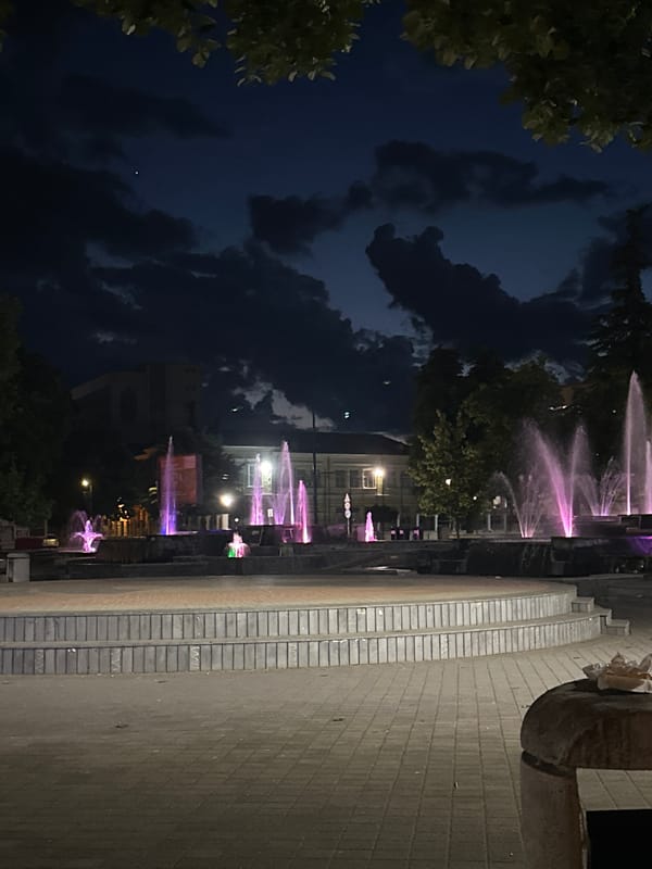 Evening scenes captured in Pazardzhik: lit fountains, young men outdoors