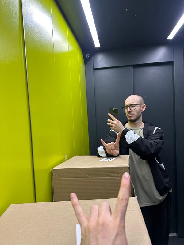 Man makes rock gesture with phone in green room