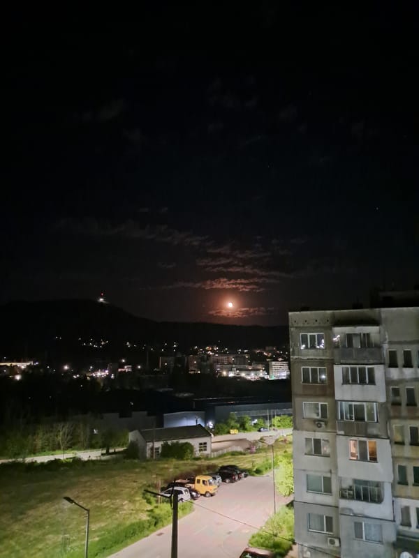 Moon visible through clouds over Gabrovo city lights