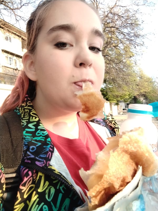 Woman enjoys early morning pastry on Plovdiv street