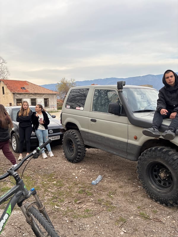Off-road enthusiasts gather with vehicles in outdoor setting