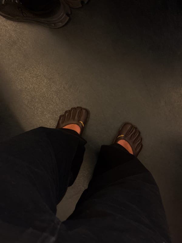 Person takes mirror selfie in dimly lit Paris location