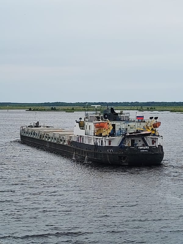 Ferry ride past cargo barge ГВАРДЕЙСК on a Russian river