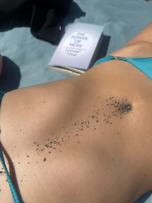 Beachgoer reads Eckhart Tolle while sunbathing on Lipari