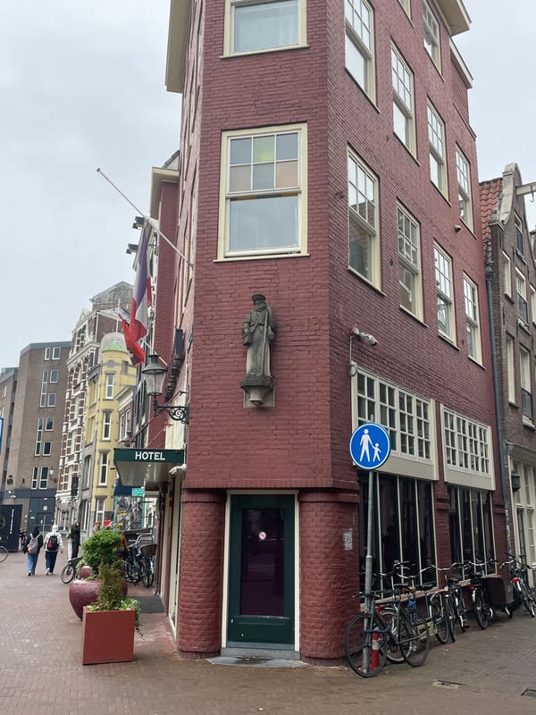 Tourist boat navigates Amsterdam canal amid historic brick buildings