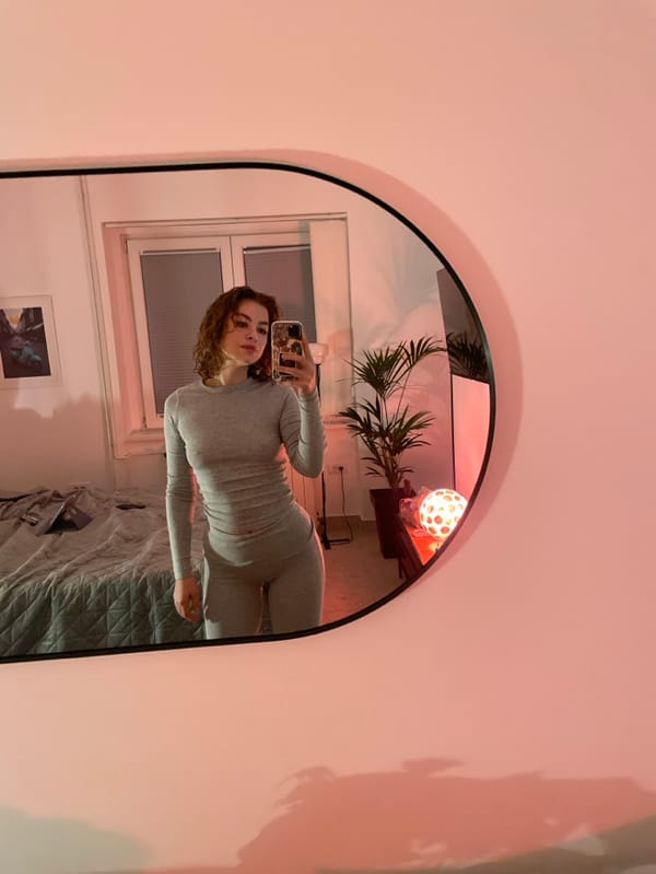 Woman takes mirror selfie in Belgrade bedroom