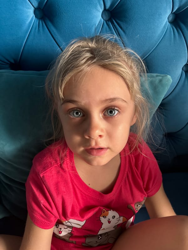 Young girl rests on blue cushioned furniture