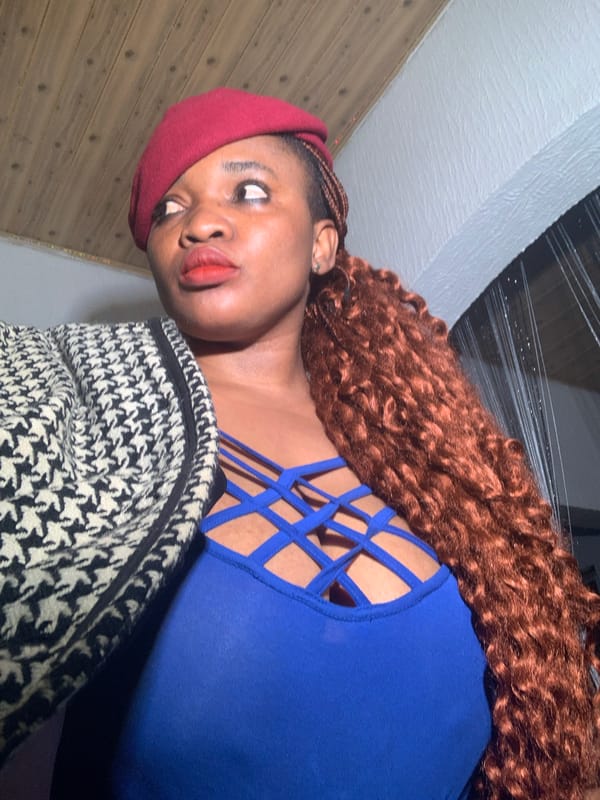 Woman takes indoor selfies in red beret, Nigeria