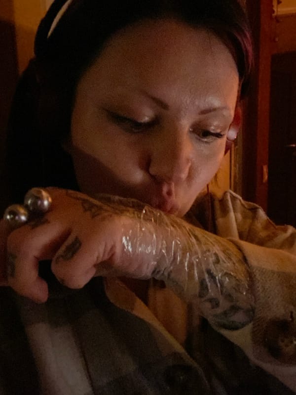 Tattooed woman with headphones rests in Kunje, Montenegro