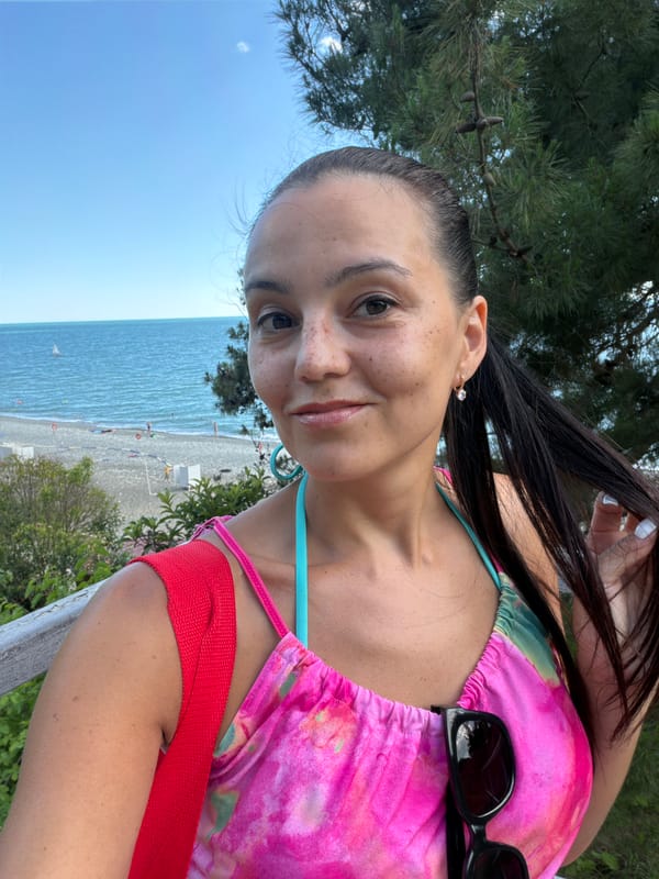 Outdoor portrait session, hair back, faint smile near the beach