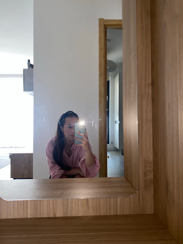 Mirror selfie session in a Bucharest apartment, pink striped shirt.