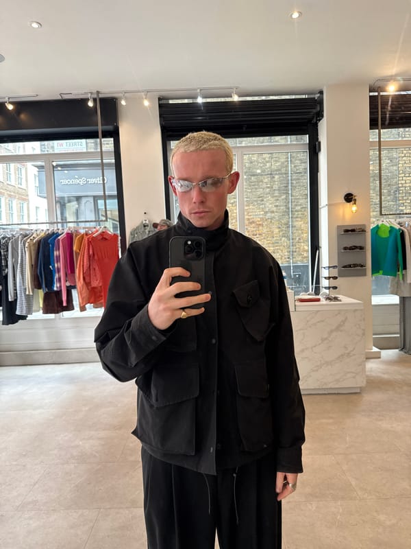 Person takes selfie in London wearing utility jacket